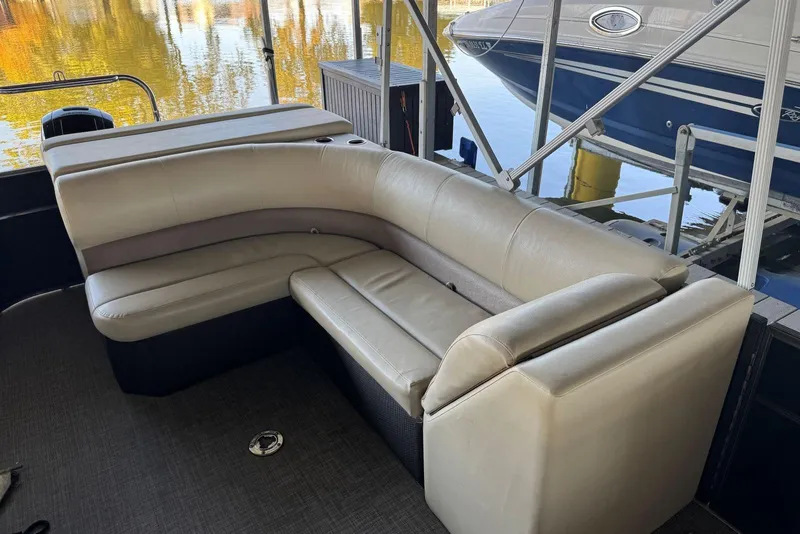 Slide: The Image of 2015 Crest 22 Crest I boat interior with beige seating, docked near water. - 9