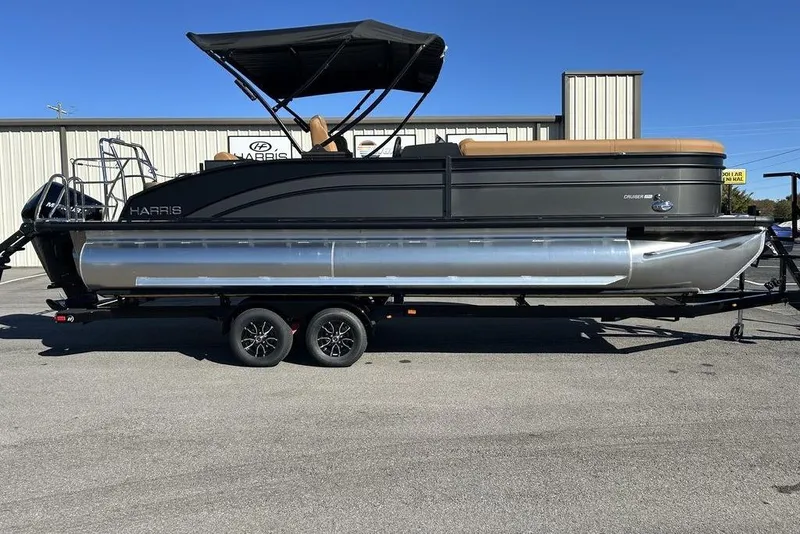 The Image of 2026 Harris Cruiser 250 LUX pontoon boat on trailer, black and silver design. - 0