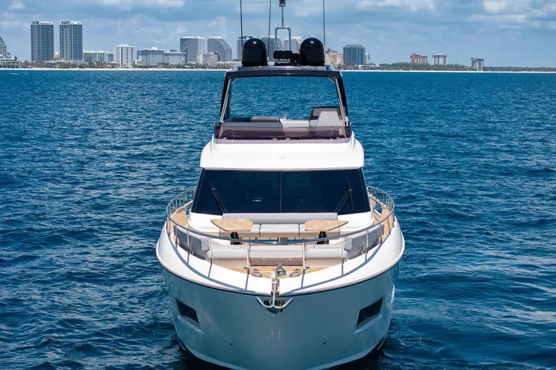 Slide: The Image of 2022 Ferretti Yachts 670 on open water with city skyline backdrop. - 1