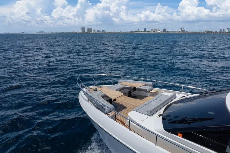 Slide: The Image of Luxurious 2022 Ferretti Yachts 670 cruising on open sea with city skyline in background. - 12