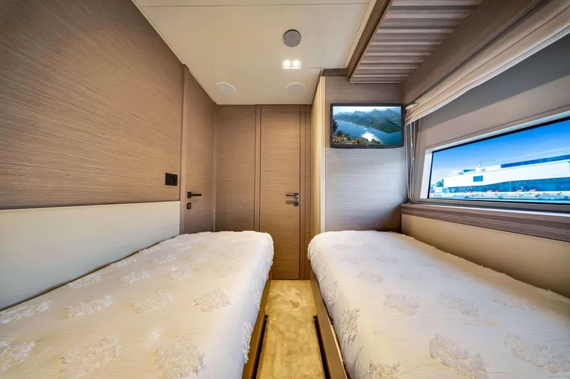 Slide: The Image of Luxurious twin bedroom in 2022 Ferretti Yachts 670, featuring modern design and scenic window view. - 56