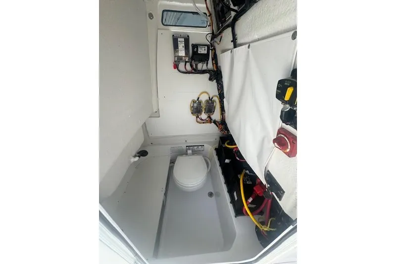 Slide: The Image of Interior of 2025 Sportsman Open 232 Center Console boat, featuring electrical components and a marine toilet. - 5
