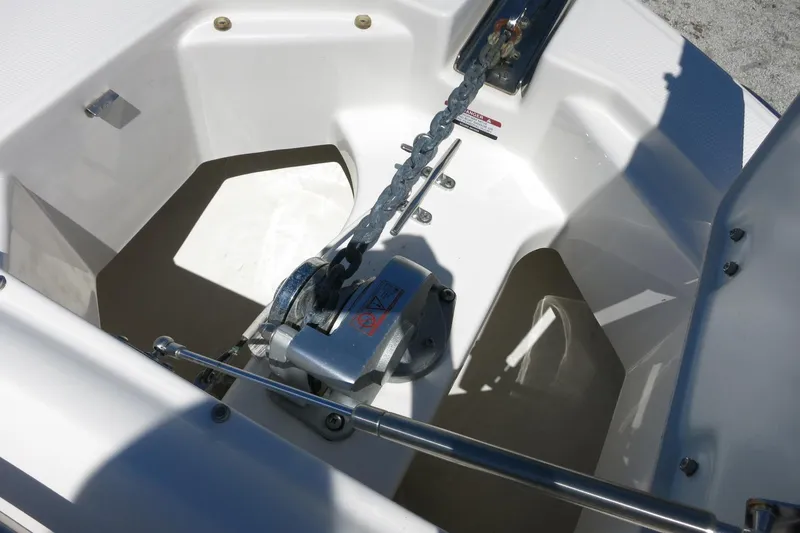 Slide: The Image of Anchor compartment of 2021 Robalo R247 Dual Console boat with chain and winch. - 14