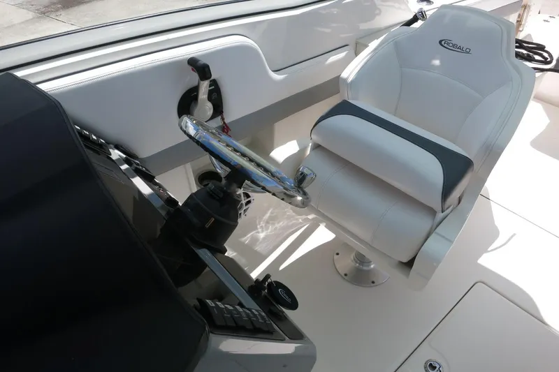 Slide: The Image of 2021 Robalo R247 Dual Console helm with steering wheel and captain's chair. - 17