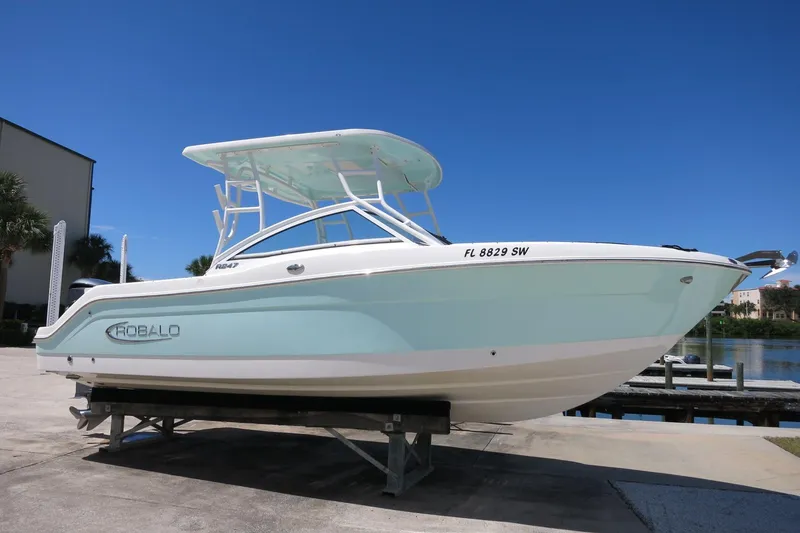 Slide: The Image of 2021 Robalo R247 Dual Console boat on display under clear blue sky. - 2