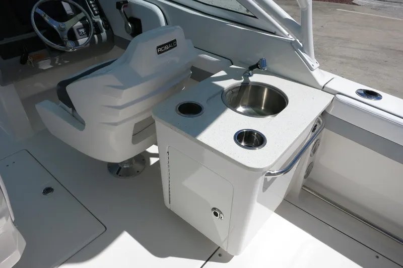 Slide: The Image of 2021 Robalo R247 Dual Console boat interior with helm seat and sink station. - 21