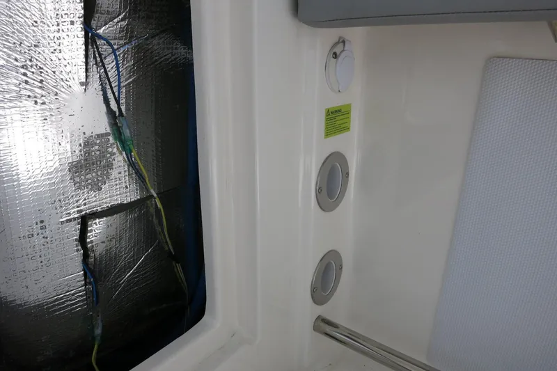Slide: The Image of Interior view of a 2021 Robalo R247 Dual Console boat, showing wiring and ventilation. - 23