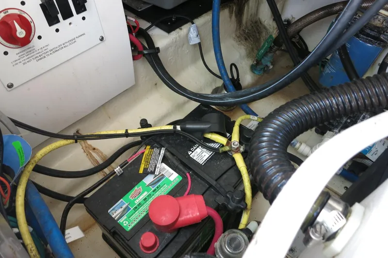 Slide: The Image of 2021 Robalo R247 Dual Console boat battery compartment with wiring and connections. - 26