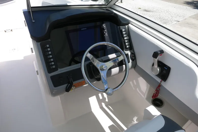Slide: The Image of 2021 Robalo R247 Dual Console boat helm with steering wheel and controls. - 28