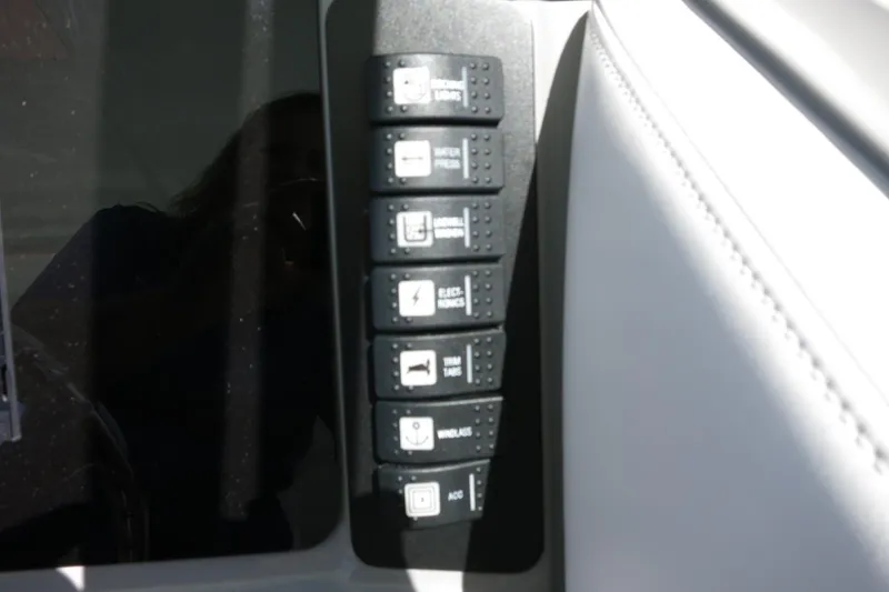 Slide: The Image of Control panel of 2021 Robalo R247 Dual Console boat with labeled switches. - 32