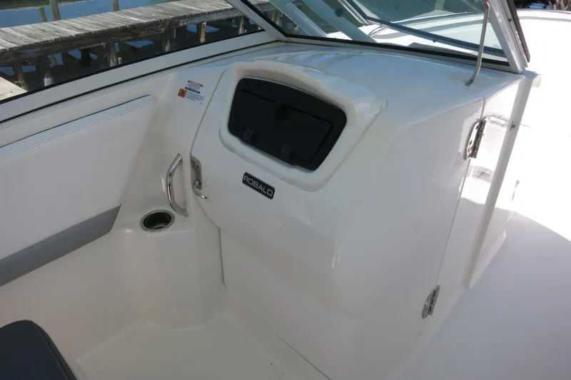 Slide: The Image of 2021 Robalo R247 Dual Console boat interior with storage compartment and cup holder. - 36