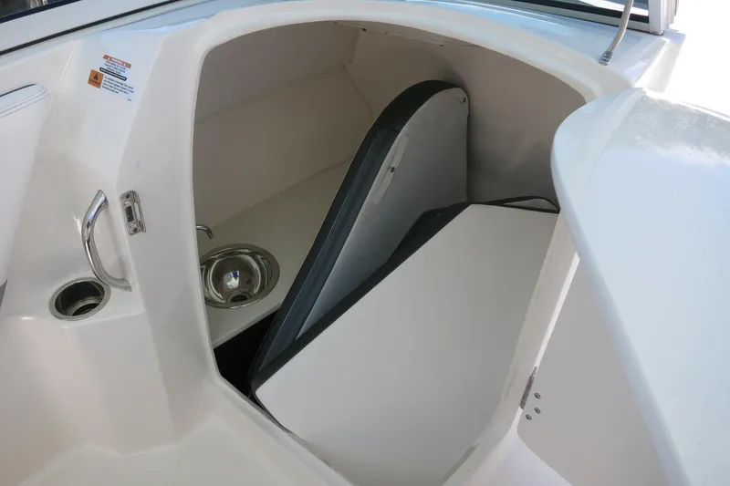 Slide: The Image of 2021 Robalo R247 Dual Console boat interior with sink and storage area. - 37
