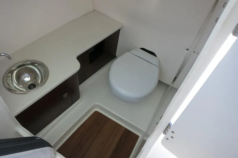 Slide: The Image of 2021 Robalo R247 Dual Console boat bathroom with sink and toilet. - 38