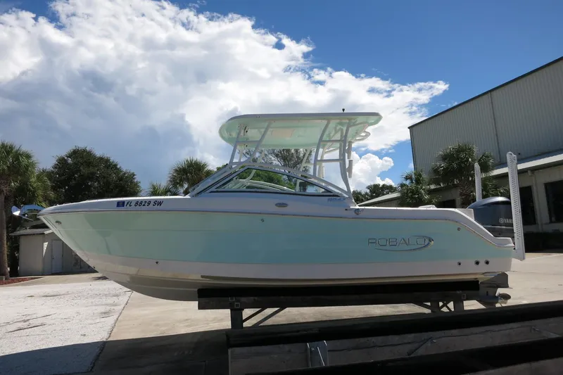 Slide: The Image of 2021 Robalo R247 Dual Console boat on trailer under blue sky. - 4