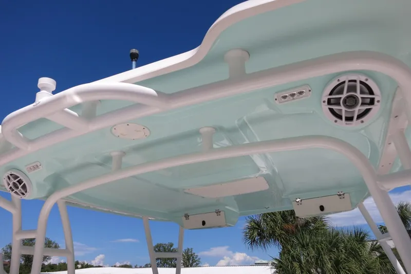 Slide: The Image of 2021 Robalo R247 Dual Console boat top with speakers and blue sky background. - 41