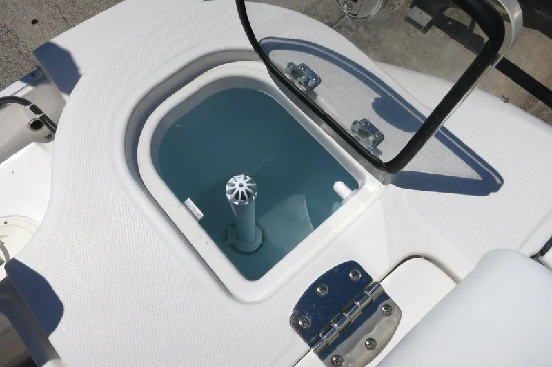 Slide: The Image of Livewell on 2021 Robalo R247 Dual Console boat, featuring a hinged lid and water circulation system. - 46