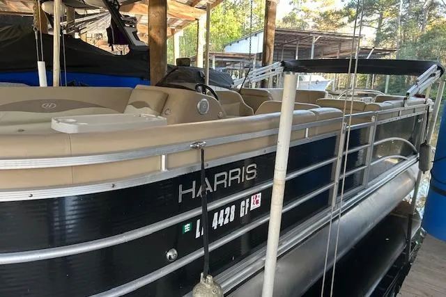Slide: The Image of 2016 Harris Cruiser 240 pontoon boat docked in a covered marina. - 2