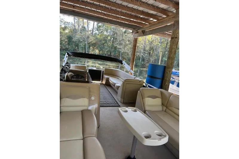 Slide: The Image of 2016 Harris Cruiser 240 pontoon boat interior with beige seating under a wooden canopy. - 4
