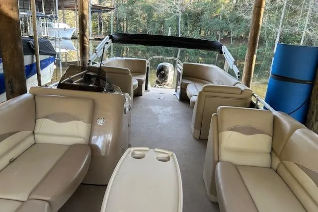 Slide: The Image of 2016 Harris Cruiser 240 pontoon boat with beige seating, docked in a wooded area. - 7