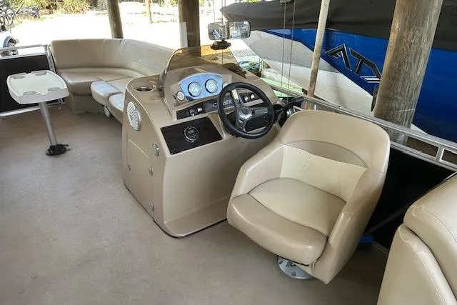Slide: The Image of 2016 Harris Cruiser 240 boat interior with beige seating and steering console. - 8
