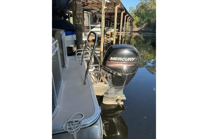 Slide: The Image of 2016 Harris Cruiser 240 with Mercury outboard motor docked on calm water. - 9