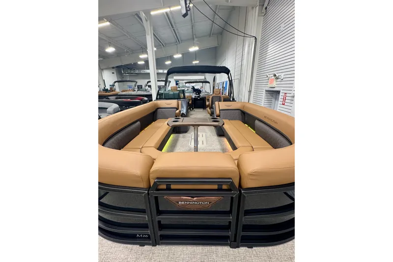 Slide: The Image of 2026 Bennington 26 MFBSF pontoon boat with luxurious tan seating in showroom. - 35