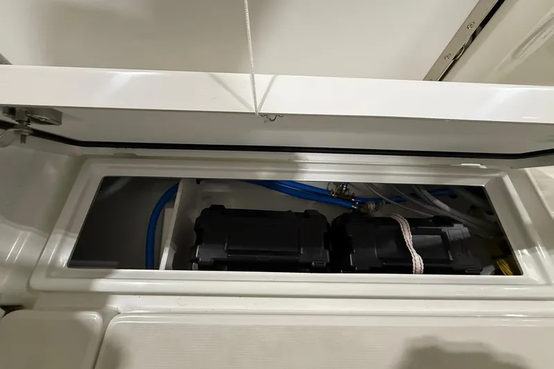 Slide: The Image of 2024 Jeanneau NC Sport 795 Series 2 storage compartment with equipment and wiring. - 11
