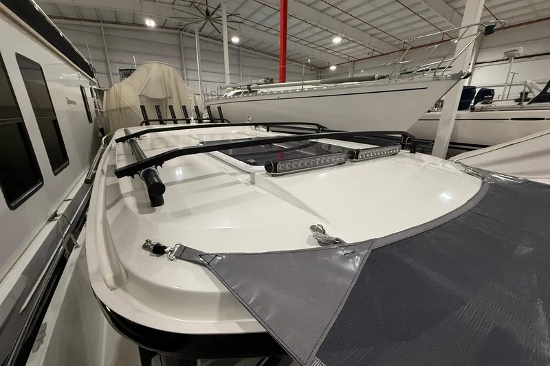 Slide: The Image of 2024 Jeanneau NC Sport 795 Series 2 boat in indoor storage, showcasing roof details. - 13