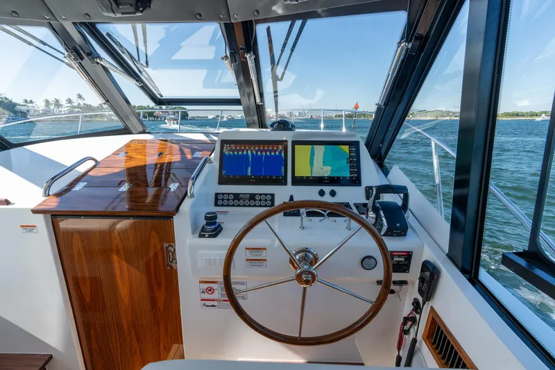 Slide: The Image of Helm of 2025 MJM 42 boat with navigation screens and wooden accents. - 10