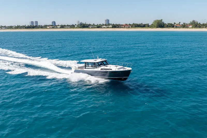 The Image of 2025 MJM 42 boat cruising on clear blue ocean near coastline. - 2