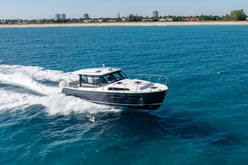 Slide: The Image of 2025 MJM 42 yacht cruising on blue ocean near sandy coastline. - 8