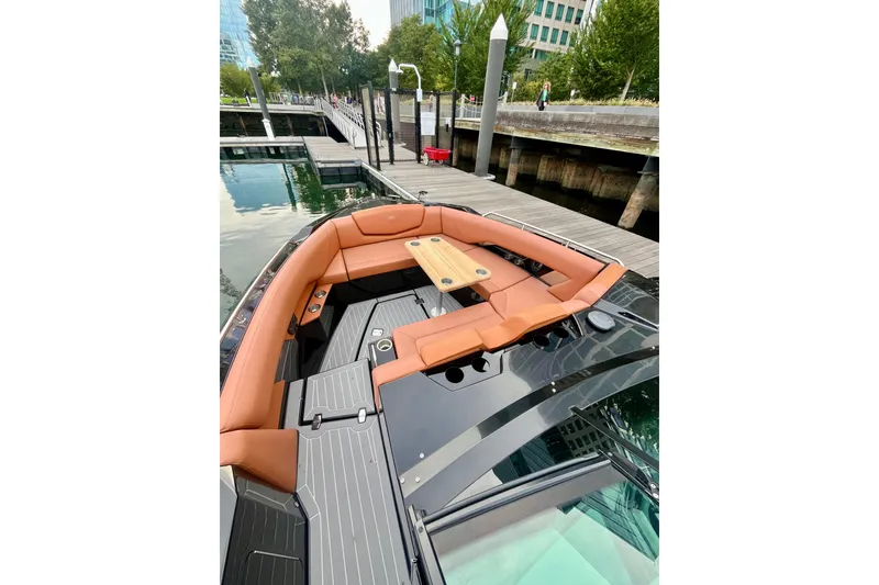 Slide: The Image of 2022 Cruisers Yachts 338 South Beach Edition Bow Rider docked, featuring luxurious seating and table. - 17