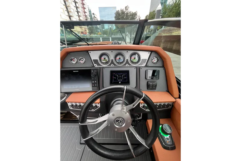 Slide: The Image of 2022 Cruisers Yachts 338 South Beach Edition Bow Rider dashboard with modern controls and steering wheel. - 26