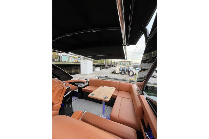 Slide: The Image of 2022 Cruisers Yachts 338 South Beach Edition Bow Rider interior with tan seating and wooden table. - 51