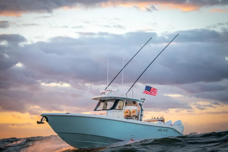 The Image of 2026 Solace 35 CS boat cruising at sunset with American flag. - 0