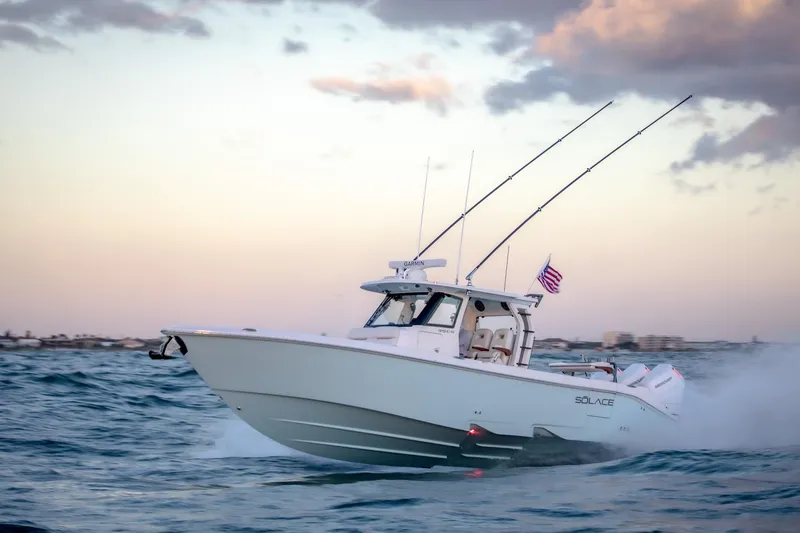 Slide: The Image of 2026 Solace 35 CS boat cruising on ocean at sunset with American flag. - 6