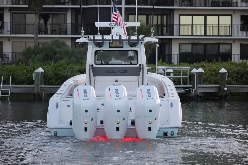 Slide: The Image of 2026 Solace 35 CS boat with triple outboard engines on water, rear view. - 7