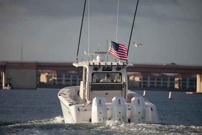 Slide: The Image of 2026 Solace 35 CS boat cruising under a bridge with American flag. - 8