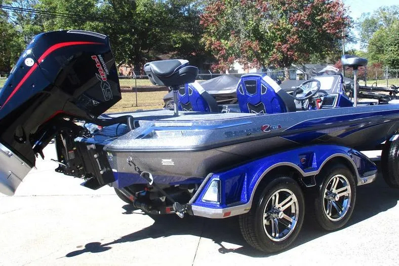 Slide: The Image of 2026 Ranger Z519 Ranger Cup Equipped boat, blue and silver, on a trailer in a sunny outdoor setting. - 7