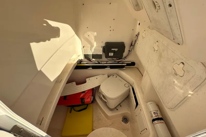 Slide: The Image of Interior of 2009 Everglades 230 Center Console boat with storage and portable toilet. - 16