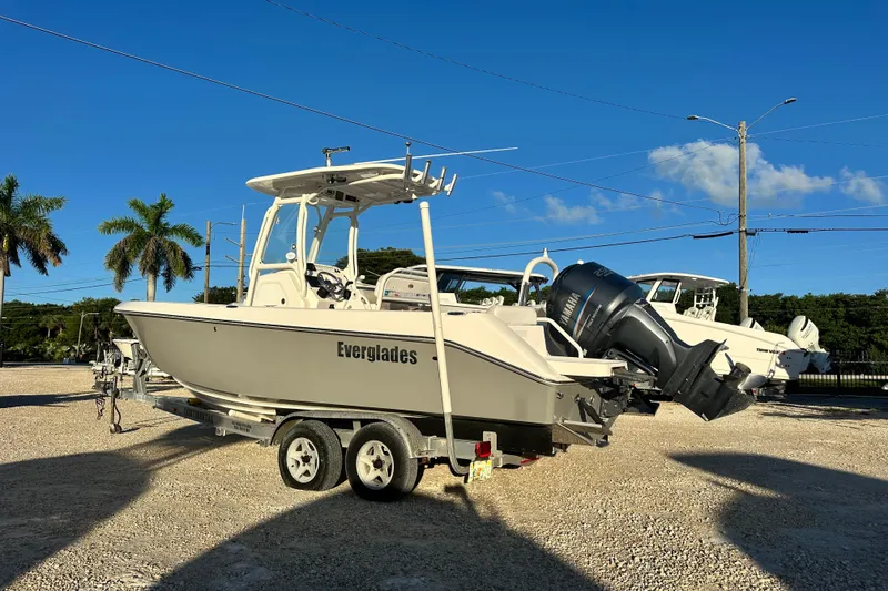 Slide: The Image of 2009 Everglades 230 Center Console boat on trailer, parked outdoors under clear blue sky. - 3