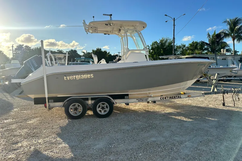 Slide: The Image of 2009 Everglades 230 Center Console boat on trailer, parked outdoors under clear sky. - 6