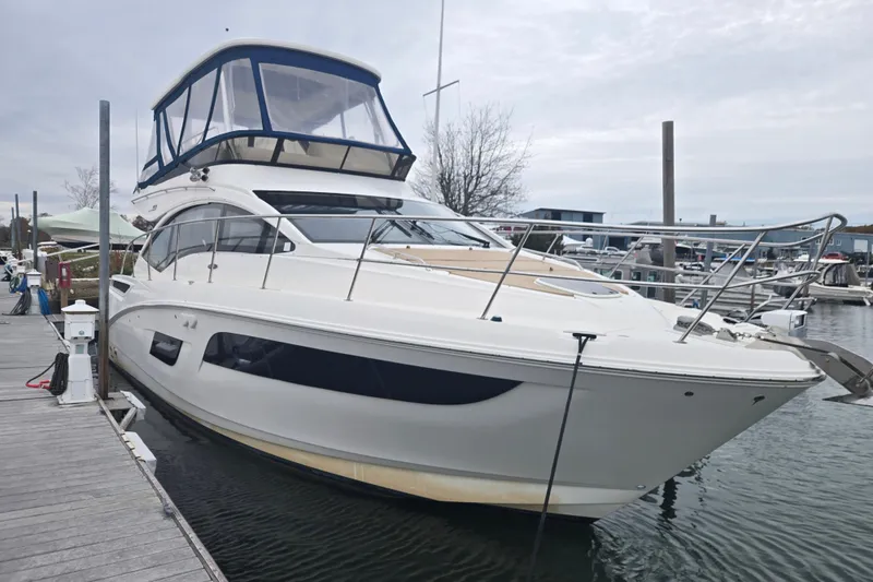 The Image of 2016 Sea Ray 400 Fly yacht docked at a marina, featuring sleek design and spacious flybridge. - 0