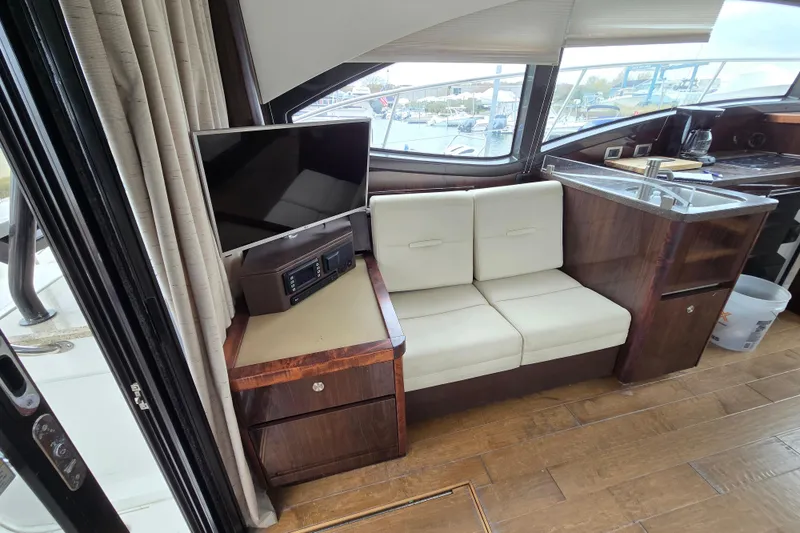 Slide: The Image of Interior of 2016 Sea Ray 400 Fly yacht with seating, TV, and kitchenette. - 17