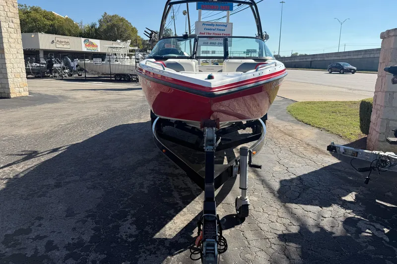 Slide: The Image of 2012 Moomba Mobius LSV boat on trailer, parked outdoors in a dealership lot. - 2
