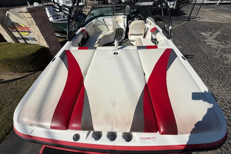 Slide: The Image of 2012 Moomba Mobius LSV boat with red and white interior, parked outdoors. - 6