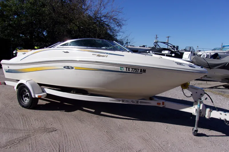 The Image of 2007 Sea Ray 185 Sport boat on trailer, parked outdoors under clear blue sky. - 1