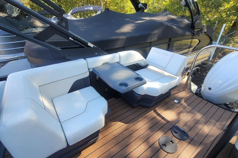 Slide: The Image of 2025 Manitou Explore 26 Switchback boat interior with white seating and table on deck. - 21