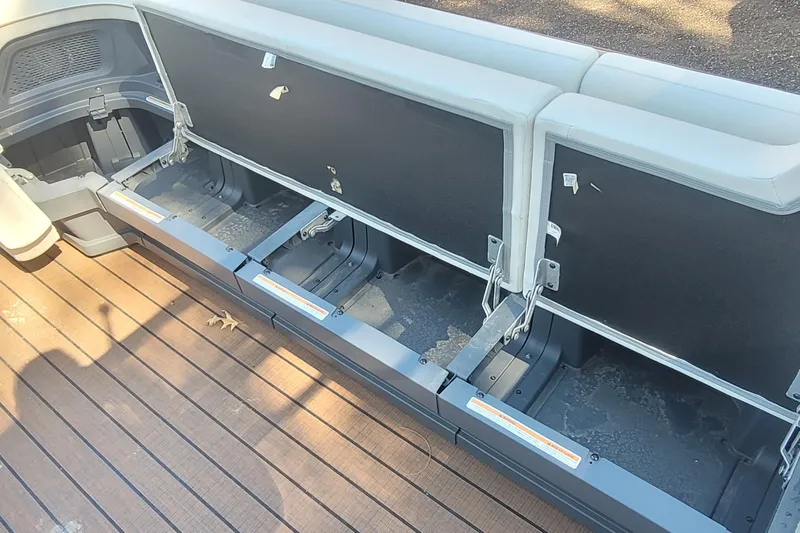 Slide: The Image of Open storage compartments on 2025 Manitou Explore 26 Switchback boat deck. - 23