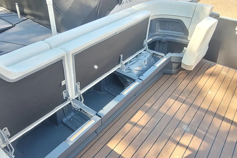 Slide: The Image of 2025 Manitou Explore 26 Switchback boat with open storage compartments on deck. - 24